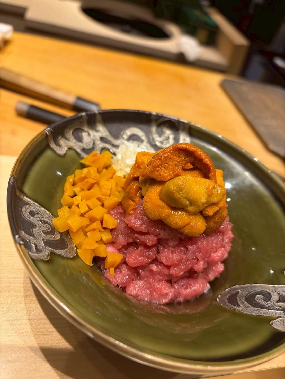 鉢に盛られた粗挽き肉の上にウニをのせた一品料理